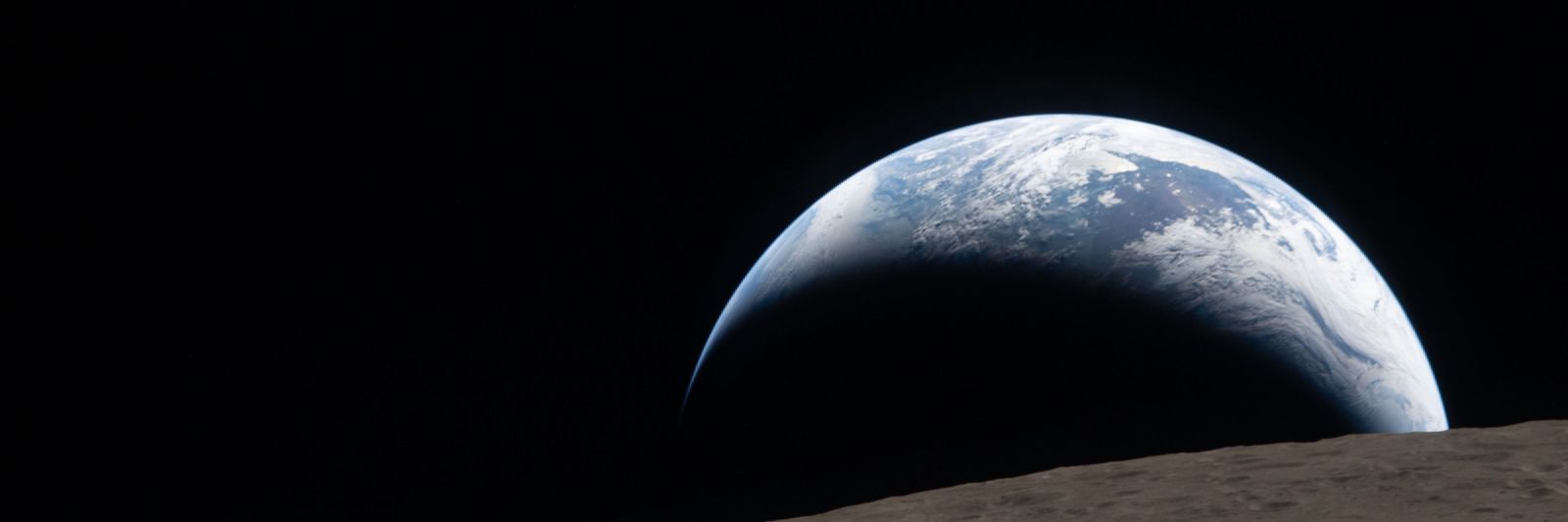 The Earth rising over the Moon's horizon